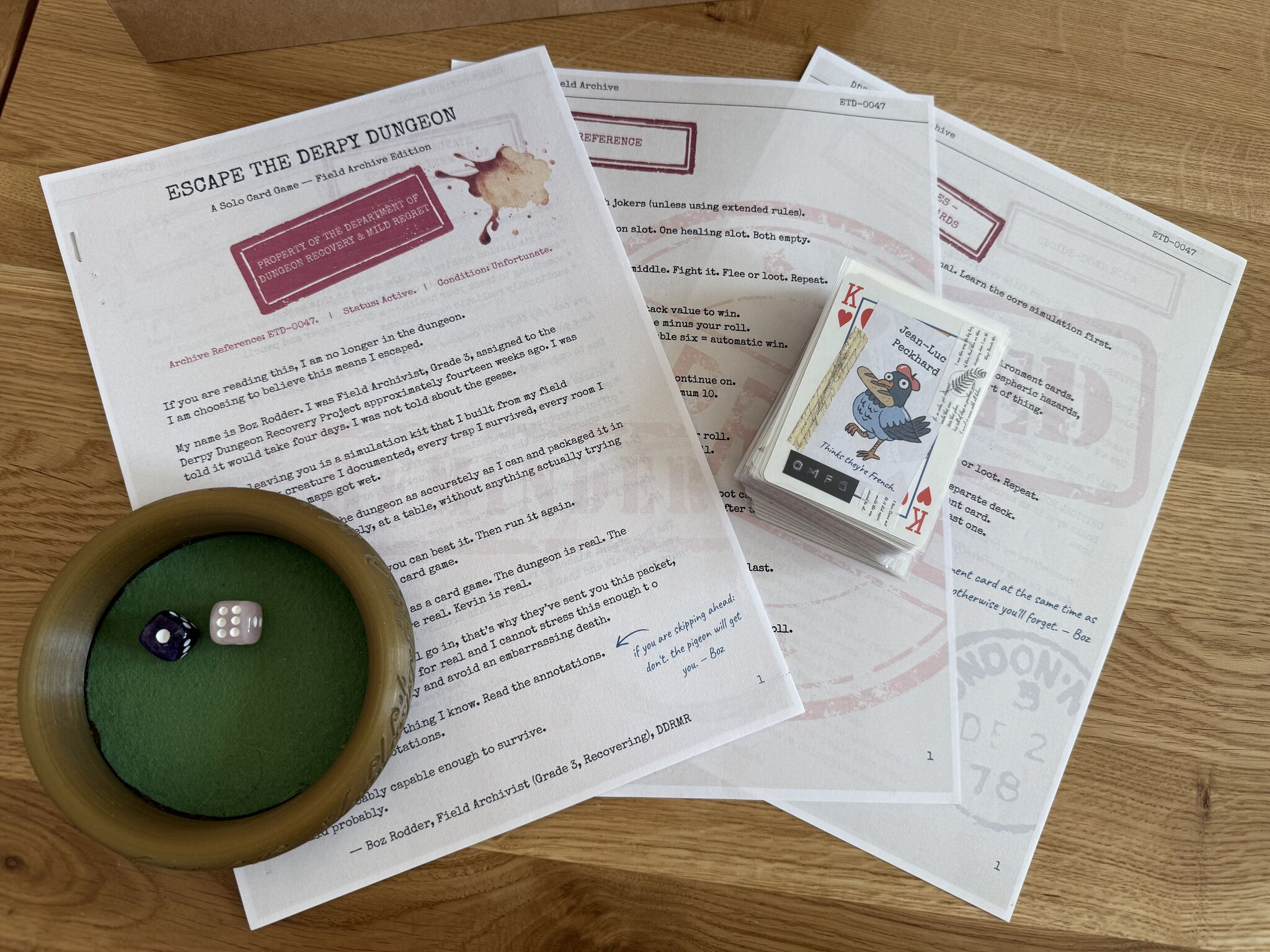 the printed rulebook packet for Escape the Derpy Dungeon, styled as a "Field Archive" report, next to a stack of playing cards and two dice in a wooden bowl